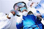 Male surgeon and two female surgeons making Thumbs Up sign