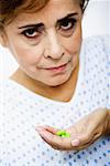 Portrait of a senior woman holding pills