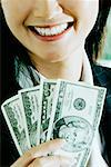 Close-up of a businesswoman holding American dollar bills and smiling