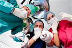 Low angle view of two male surgeons and a female surgeon looking surprised