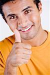 Portrait of a young man showing Thumbs Up sign and smiling