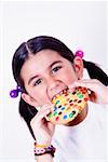 Portrait d'une jeune fille mangeant un beignet