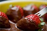 Close-up of a fork with chocolate covered strawberries