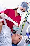 Weibliche Chirurg eine Sauerstoffmaske auf einer Patientin Gesicht setzen