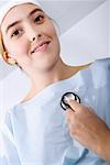 Close-up of a doctor's hand holding a stethoscope and examining a female patient