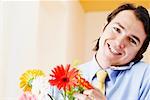 Portrait d'un homme d'affaires tenant des fleurs et de parler sur un téléphone mobile