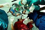 Low angle view of three male surgeons and a female surgeon holding surgical equipments