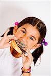 Portrait d'une jeune fille mangeant un beignet