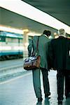 Rear view of two men walking at a railroad station platform, Rome, Italy