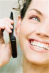 Close-up of a young woman holding a mobile phone and smiling