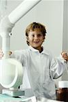 Portrait d'un garçon imitant un médecin et d'une machine à rayons x