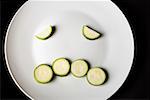 Close-up of slices of zucchini in a plate making a frowning face