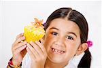 Portrait d'une jeune fille tenant un petit gâteau