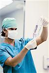 Male surgeon holding an IV drip bag