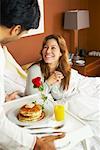 Man Serving Woman Breakfast in Bed