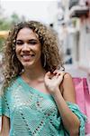 Portrait of a teenage girl carrying a shopping bag and smiling