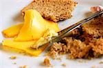 Close-up of a table knife with brown bread and cheese