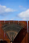 Close-up of a metal structure against a wooden fence