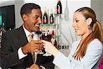 Close-up of a businessman and a businesswoman toasting with wine glasses