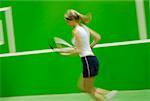 Profil de côté d'une jeune femme jouant au tennis
