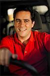 Portrait of a young man driving a car and smiling