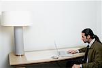 Side profile of a businessman using a laptop