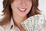 Close-up of a businesswoman holding fanned out dollar bills and smiling