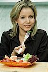 Portrait of a mid adult woman eating fruit salad