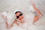 High angle view of a boy smiling in a bubble bath
