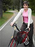 Portrait d'une femme d'âge mûr assis sur une bicyclette et souriant