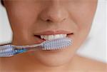 Gros plan d'une jeune femme se brosser ses dents