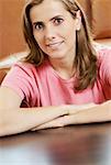 Portrait of a mid adult woman sitting at a table in a cafeteria