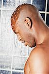 Side profile of a young man in the shower