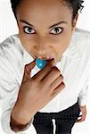 High angle view of a businesswoman holding a globe in her mouth