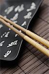 Close-up of two chopsticks and a tray