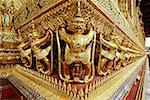 Golden statues carved on walls of a temple, Wat Phra Kaeo, Bangkok, Thailand