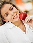 Portrait d'une femme adulte mid tenant une pomme et souriant