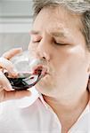 Close-up of a mature man drinking a glass of red wine