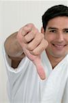 Portrait of a young man showing a thumbs down sign