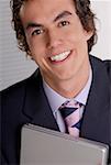 Portrait of a businessman holding a laptop and smiling