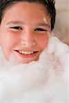 Portrait of a boy smiling in a bubble bath