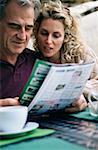 Couple looking at property magazine