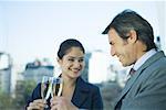 Homme d'affaires et jeune femelle associé griller avec verres de champagne