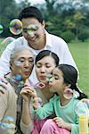 Three generation family blowing bubbles