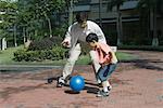 Father and son playing ball in courtyard