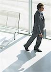 Businessman walking with briefcase, full length, high angle view