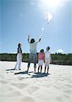 Family flying kite on beach