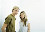 Young couple looking at camera, portrait, white background