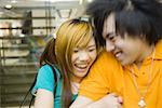 Teenage couple laughing, blurred motion