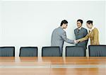 Business associates shaking hands in conference room